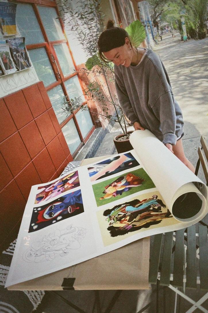 Kristine Razmajeva reviewing printed illustration work